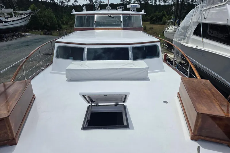 Windrush Yacht Photos Pics 1966 Trumpy 55 yacht with open hatch, docked among other boats.