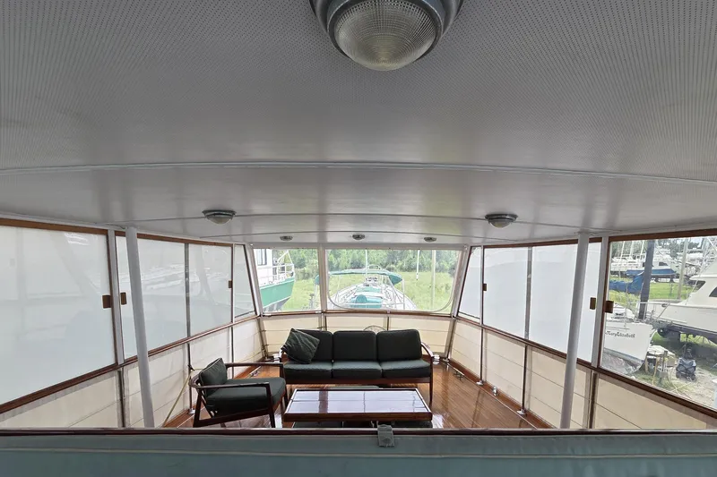 Windrush Yacht Photos Pics Luxurious interior of a 1966 Trumpy 55 yacht with elegant seating and panoramic windows.