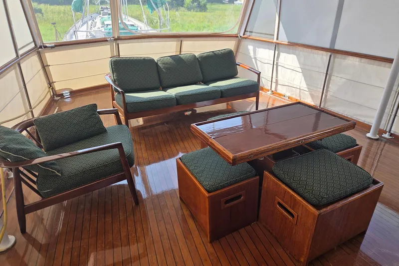 Windrush Yacht Photos Pics Luxurious 1966 Trumpy 55 yacht interior with elegant wooden furniture and green cushions.