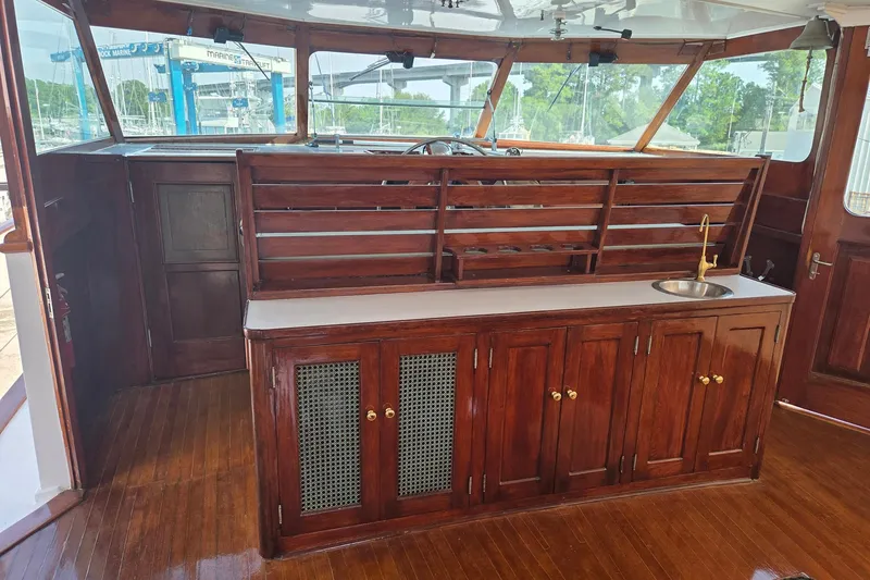 Windrush Yacht Photos Pics Interior of a 1966 Trumpy 55 yacht with polished wood cabinetry and a small sink.