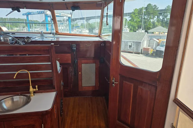 Windrush Yacht Photos Pics Interior of a 1966 Trumpy 55 boat with wooden finish and brass fixtures.