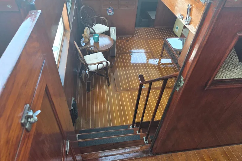 Windrush Yacht Photos Pics Interior of a 1966 Trumpy 55 yacht with polished wood flooring and cozy seating area.