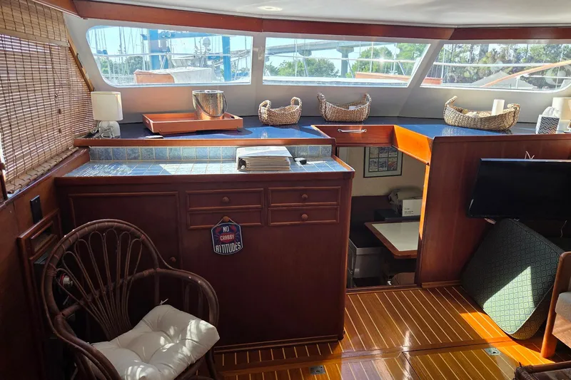 Windrush Yacht Photos Pics Interior of a 1966 Trumpy 55 yacht with wooden furnishings and wicker baskets.