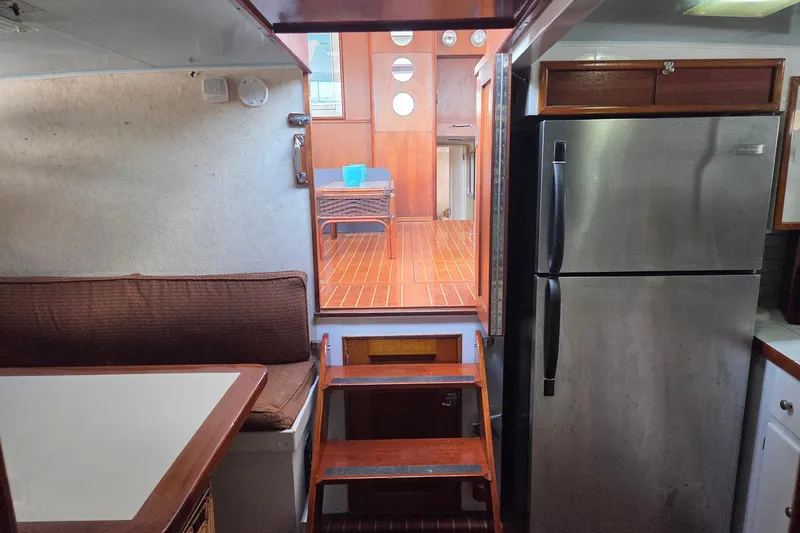 Windrush Yacht Photos Pics Interior of a 1966 Trumpy 55 yacht with kitchen and seating area.