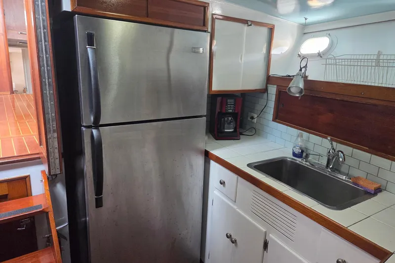 Windrush Yacht Photos Pics Kitchen area in a 1966 Trumpy 55 yacht with stainless steel fridge and sink.
