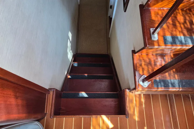 Windrush Yacht Photos Pics Wooden staircase inside a 1966 Trumpy 55 yacht, featuring rich mahogany steps.