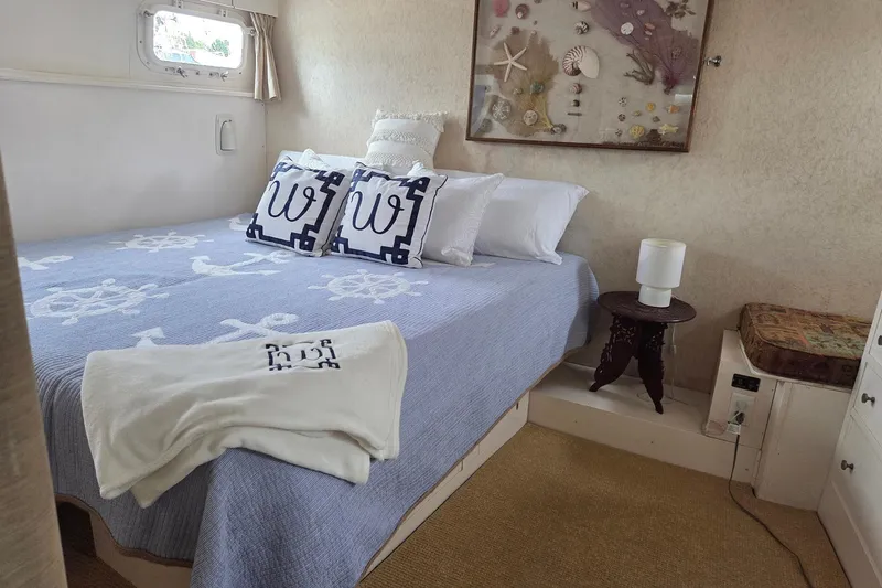 Windrush Yacht Photos Pics Cozy bedroom in 1966 Trumpy 55 yacht with nautical decor and elegant bedding.