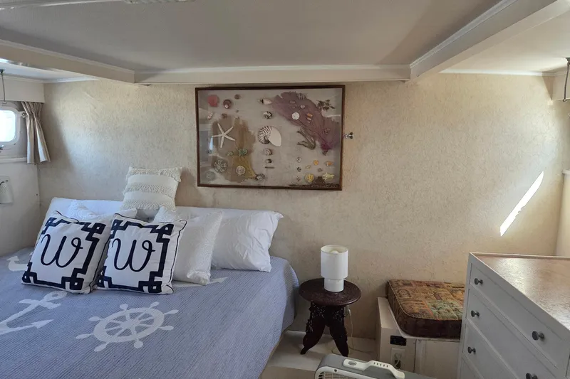 Windrush Yacht Photos Pics Cozy bedroom in 1966 Trumpy 55 yacht with nautical decor and seashell artwork.
