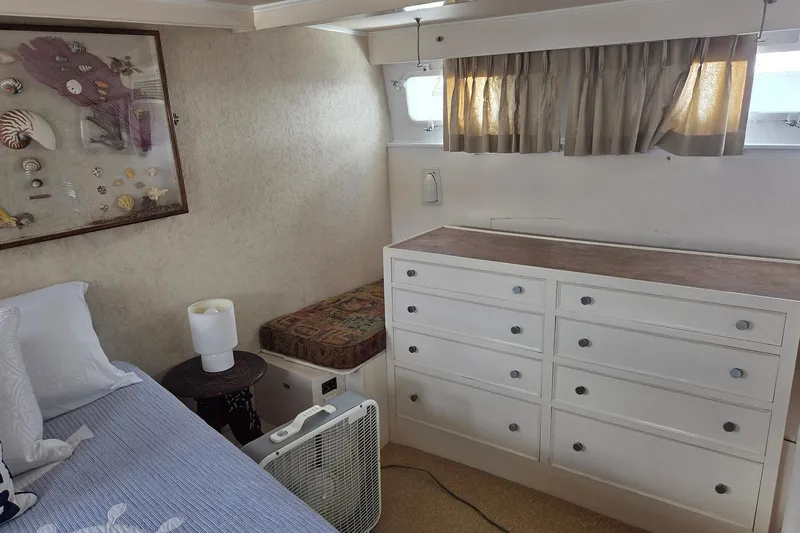 Windrush Yacht Photos Pics Cozy cabin interior of 1966 Trumpy 55 yacht with bed, dresser, and nautical decor.
