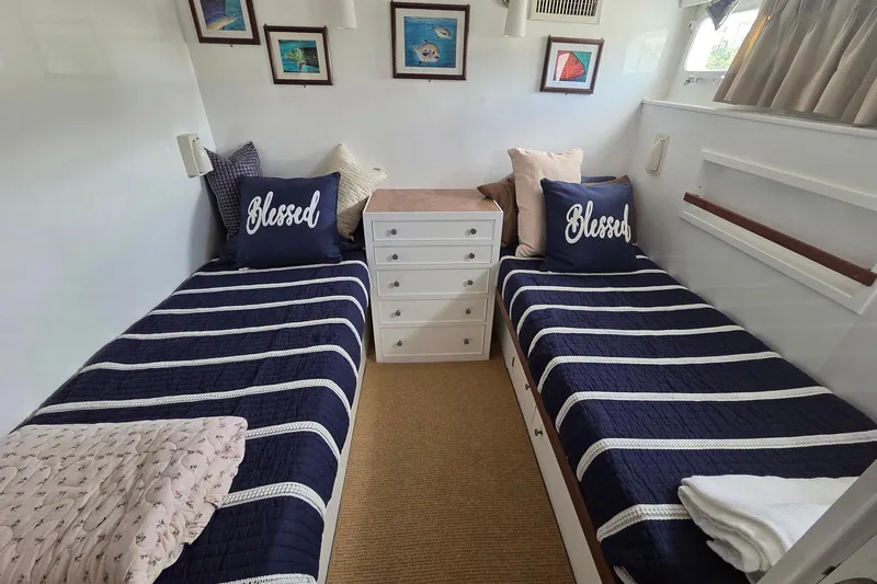 Windrush Yacht Photos Pics Twin beds in a 1966 Trumpy 55 yacht cabin with nautical decor and "Blessed" pillows.