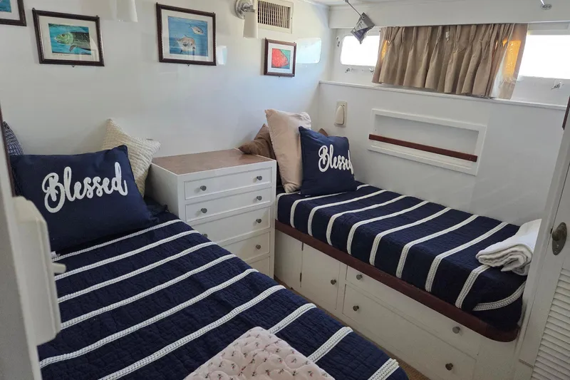 Windrush Yacht Photos Pics Cozy 1966 Trumpy 55 cabin with twin beds, nautical decor, and "Blessed" pillows.