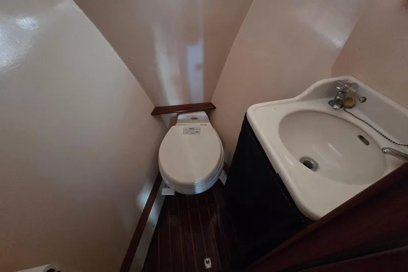 Windrush Yacht Photos Pics Compact bathroom with toilet and sink in a 1966 Trumpy 55 yacht.