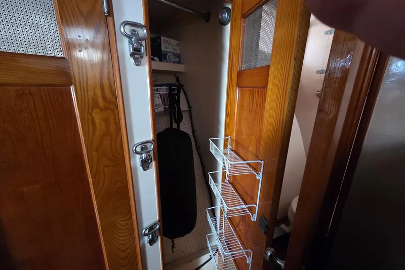 Windrush Yacht Photos Pics Wooden cabinet interior with wire shelves in a 1966 Trumpy 55 model.