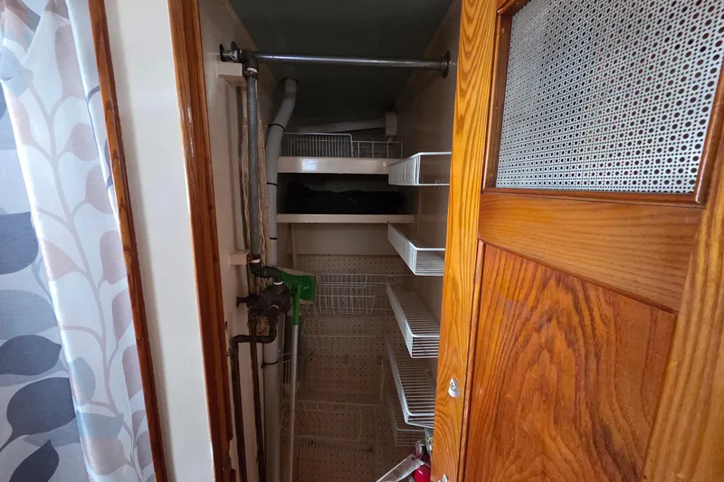Windrush Yacht Photos Pics Small storage closet with wire shelves inside a 1966 Trumpy model 55 boat.