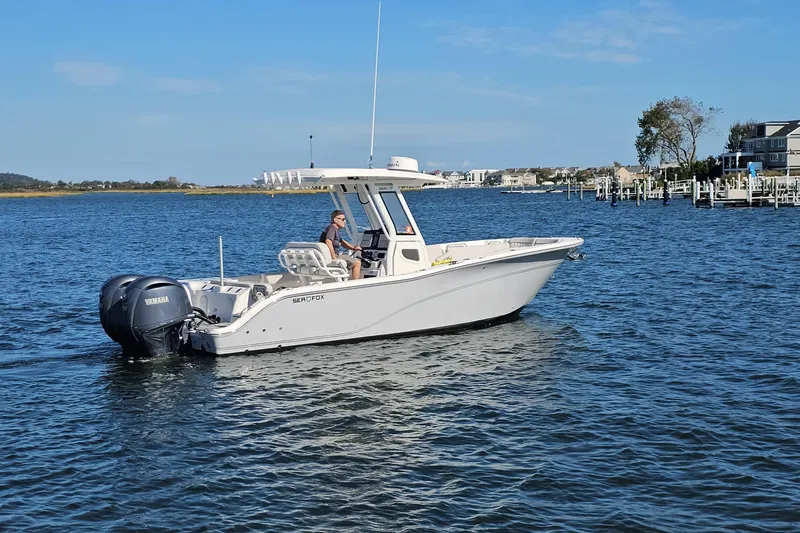  Yacht Photos Pics 2024 Sea Fox 268 Commander boat cruising on a calm lake with scenic background.