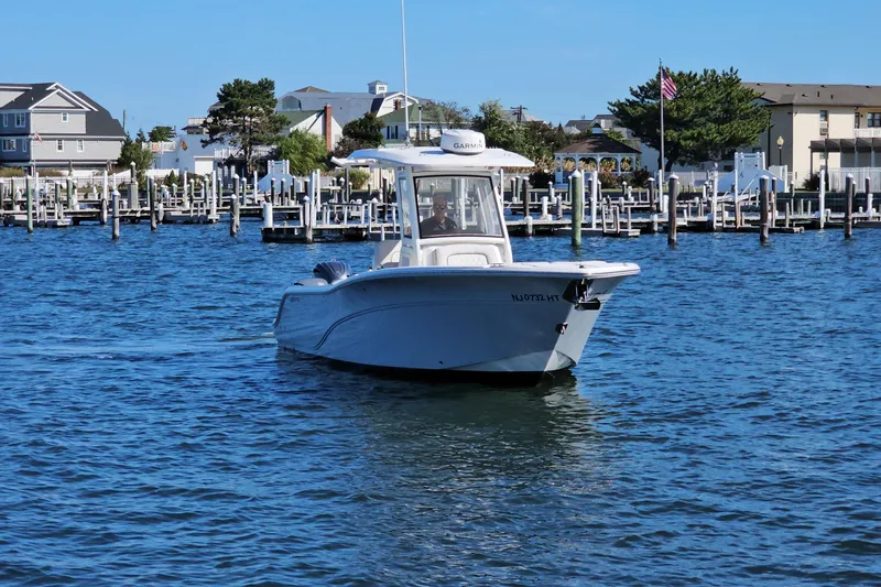  Yacht Photos Pics 2024 Sea Fox 268 Commander boat cruising in a marina with docks and buildings in the background.