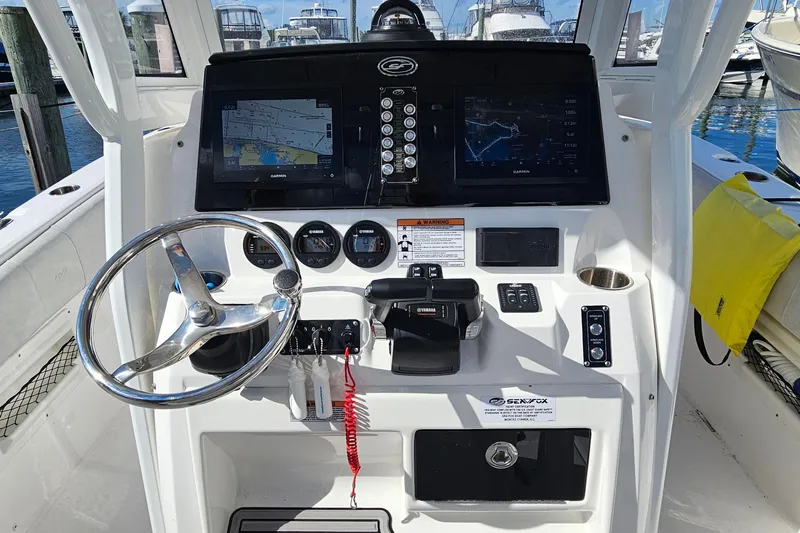  Yacht Photos Pics 2024 Sea Fox 268 Commander boat dashboard with steering wheel and navigation screens.