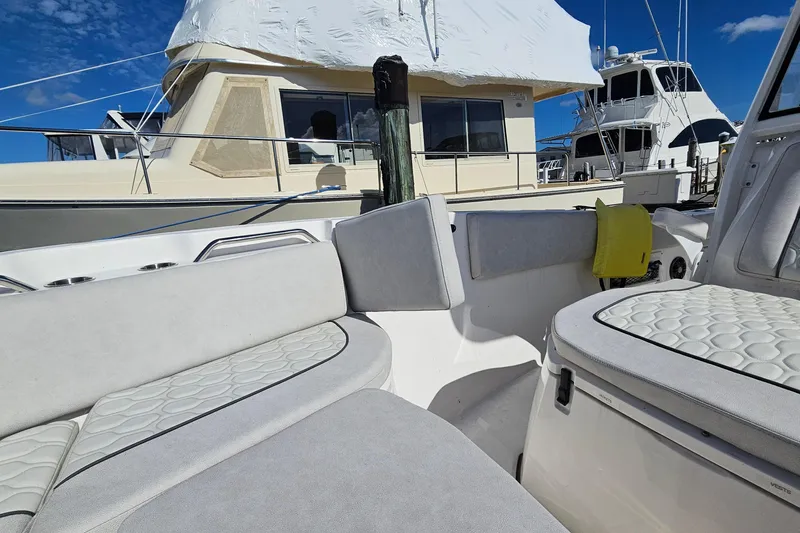  Yacht Photos Pics 2024 Sea Fox 268 Commander boat interior with cushioned seating, docked near other vessels.