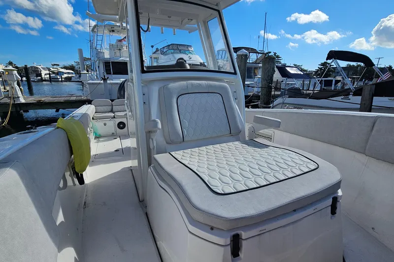  Yacht Photos Pics 2024 Sea Fox 268 Commander boat interior with cushioned seating at a marina.
