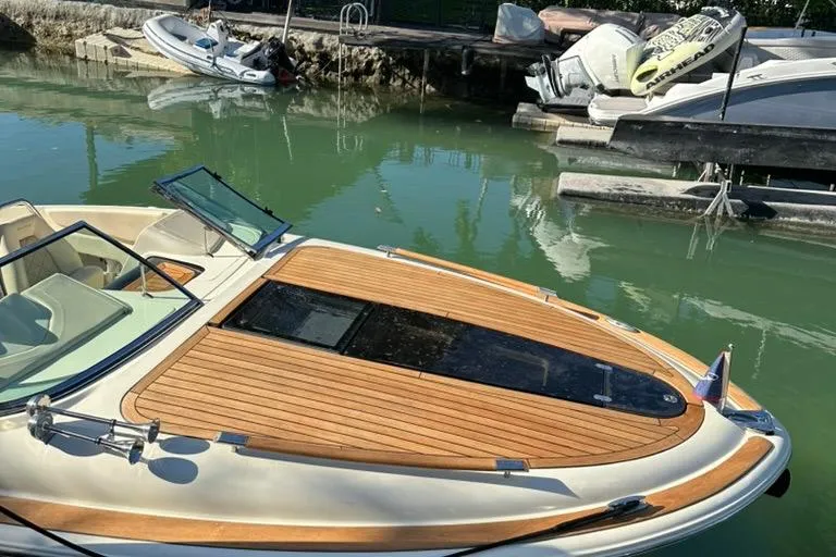 Yacht Photos Pics 2019 Chris-Craft Corsair 30 boat with wooden deck, docked in calm waters.