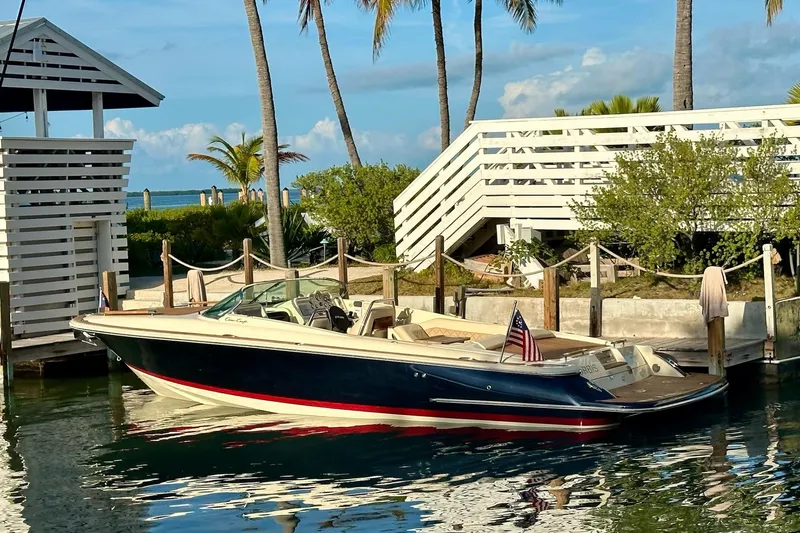  Yacht Photos Pics 2019 Chris-Craft Corsair 30 boat docked near palm trees and a white structure.