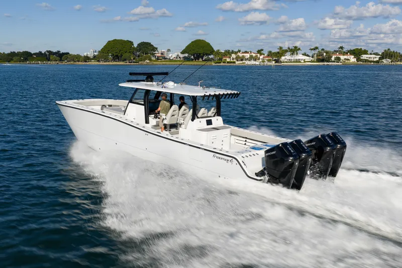 Red White And Booze Yacht Photos Pics 2022 Freeman 43 boat cruising on water with twin outboard engines.