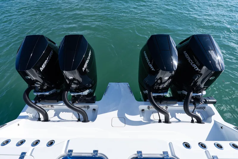 Red White And Booze Yacht Photos Pics Four Mercury outboard engines on a 2022 Freeman 43 boat, floating on clear water.
