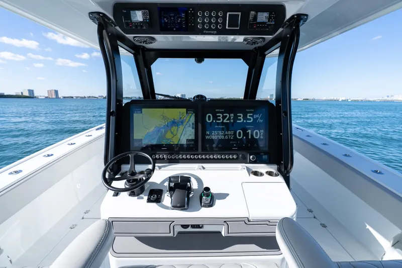 Red White And Booze Yacht Photos Pics Freeman 43 boat cockpit with navigation screens, steering wheel, and ocean view, 2022 model.