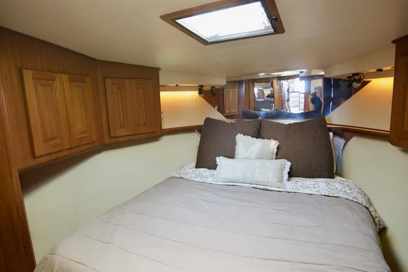 3 Hour Tour Yacht Photos Pics Cozy bedroom in 1989 Viking Convertible yacht with wooden cabinets and skylight.