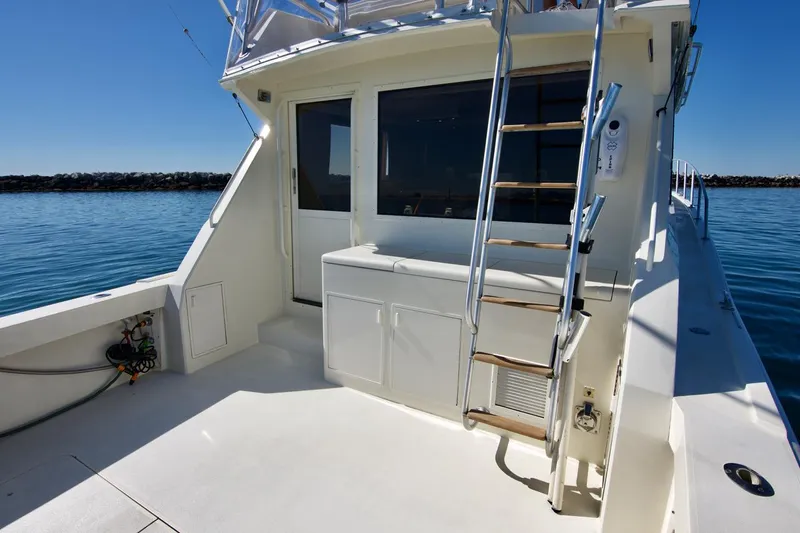 3 Hour Tour Yacht Photos Pics 1989 Viking Convertible boat deck with ladder and storage, on calm water.