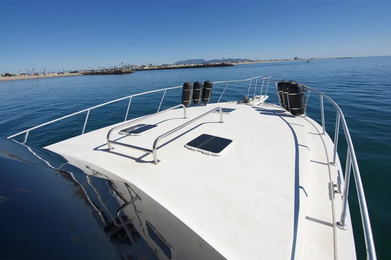 3 Hour Tour Yacht Photos Pics 1989 Viking Convertible yacht on calm ocean waters, clear sky, distant shoreline.
