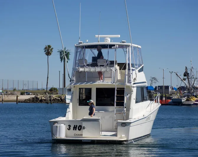 3 Hour Tour Yacht Photos Pics 1989 Viking Convertible boat cruising in a harbor with clear blue skies.