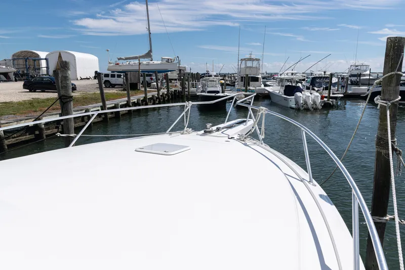  Yacht Photos Pics Bow view of a 2014 Viking 42 Express yacht docked in a marina.