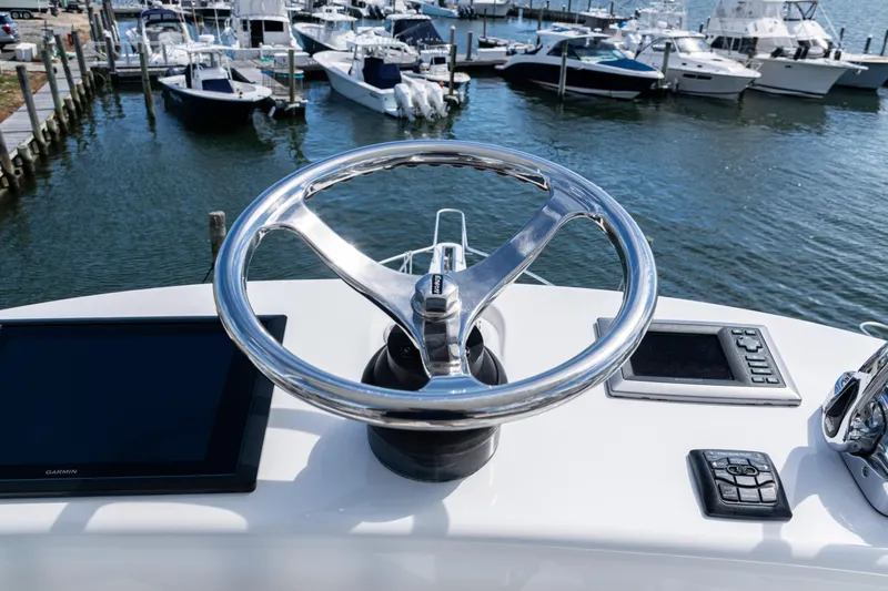  Yacht Photos Pics Steering wheel of 2014 Viking 42 Express yacht with marina view.