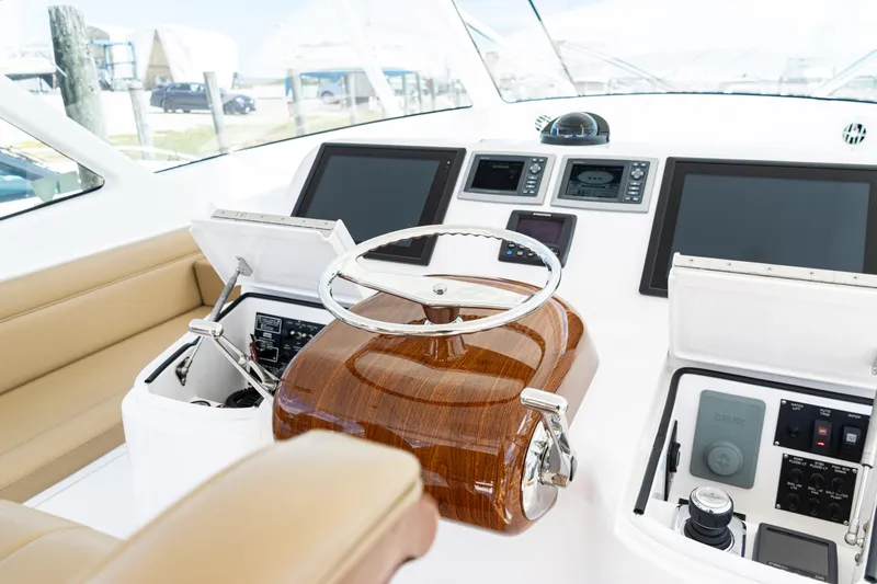  Yacht Photos Pics Helm of 2014 Viking 42 Express yacht with modern navigation controls and wooden steering wheel.