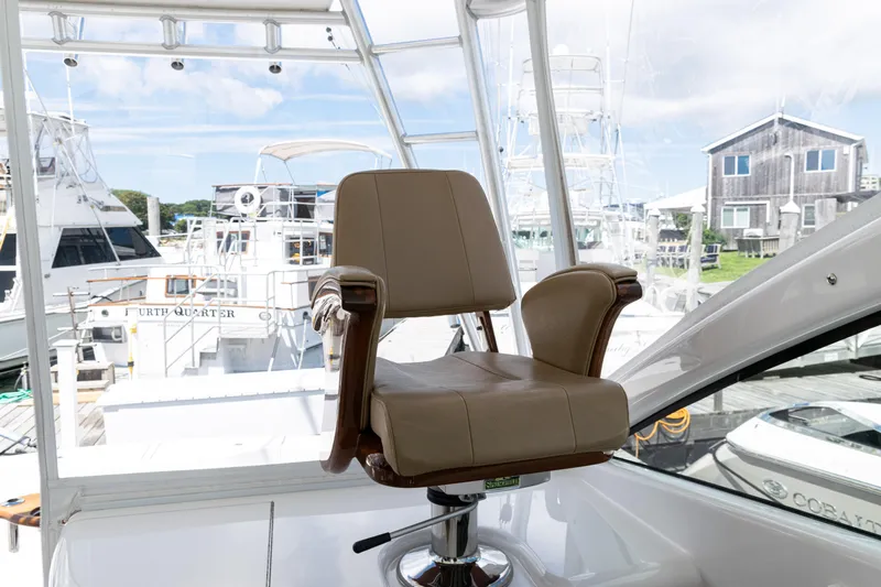  Yacht Photos Pics Captain's chair on 2014 Viking 42 Express yacht, docked with other boats in background.