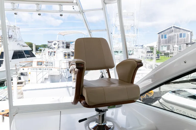  Yacht Photos Pics Captain's chair on 2014 Viking 42 Express yacht, docked with other boats in background.