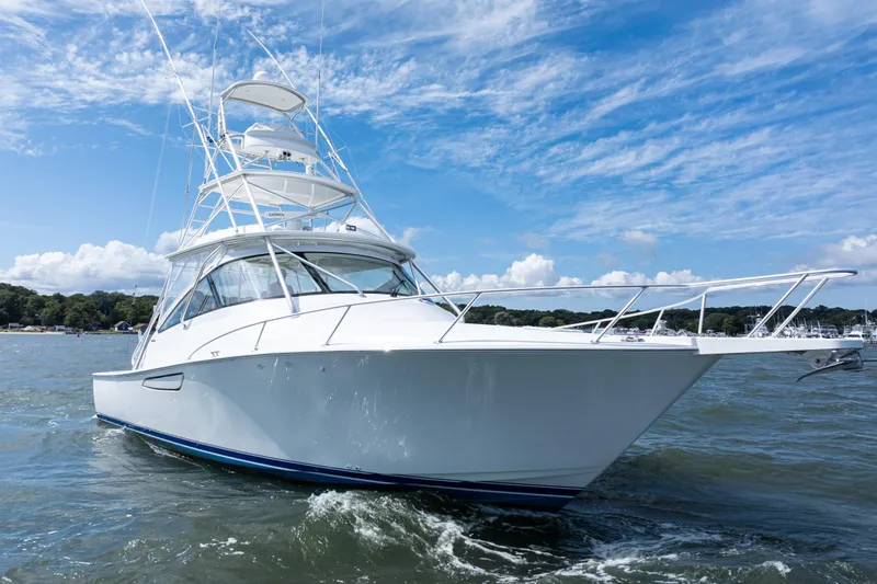  Yacht Photos Pics 2014 Viking 42 Express yacht cruising on open water under a clear blue sky.