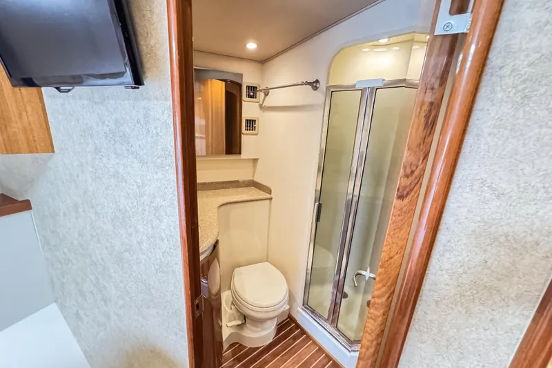  Yacht Photos Pics 2014 Viking 42 Express bathroom with shower, toilet, and wooden accents.