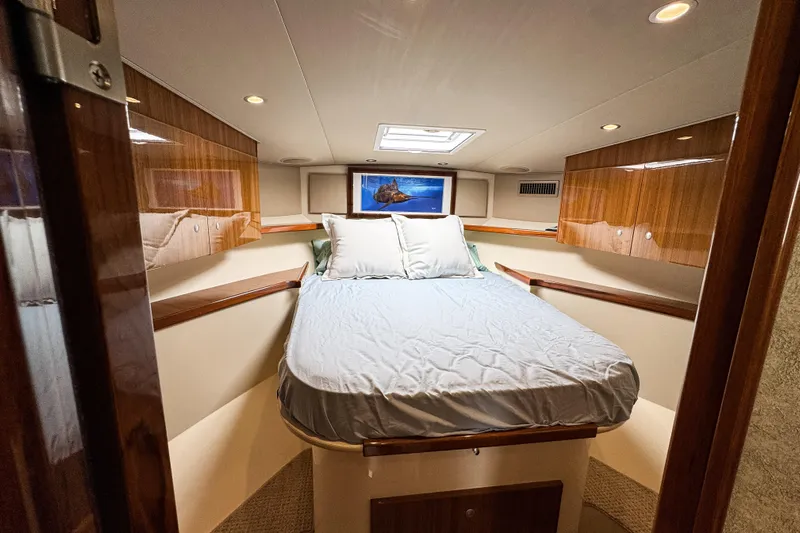  Yacht Photos Pics Luxurious cabin interior of 2014 Viking 42 Express yacht with cozy bed and wooden accents.