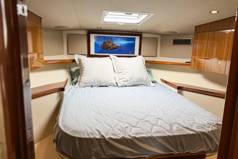  Yacht Photos Pics Luxurious cabin interior of 2014 Viking 42 Express yacht with cozy bed and wooden accents.