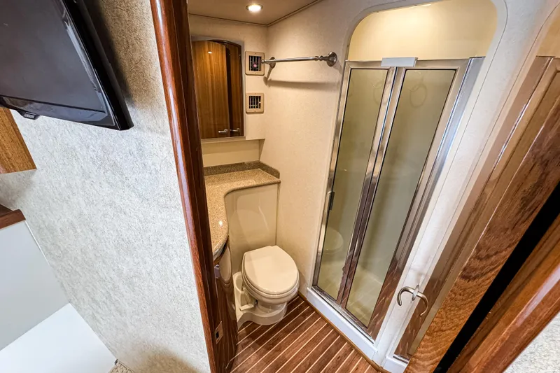  Yacht Photos Pics 2014 Viking 42 Express yacht bathroom with shower, toilet, and wooden accents.