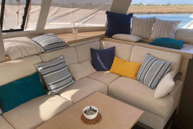  Yacht Photos Pics Luxurious interior of 2024 Fountaine Pajot Catamaran Astrea 42 with cozy cushions and scenic view.