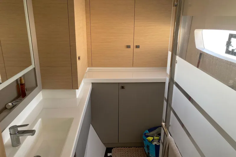  Yacht Photos Pics 2024 Fountaine Pajot Catamaran Astrea 42 bathroom with modern fixtures and wooden cabinetry.