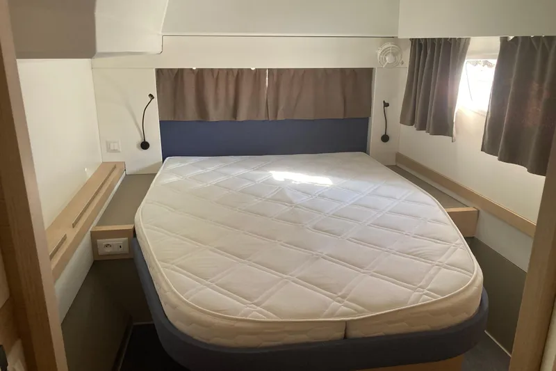  Yacht Photos Pics 2024 Fountaine Pajot Catamaran Astrea 42 cabin with a cozy bed and curtains.