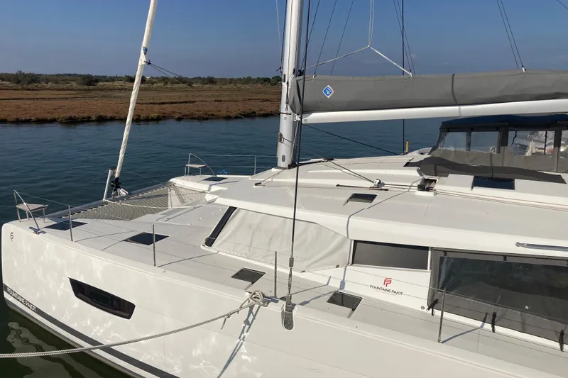  Yacht Photos Pics 2024 Fountaine Pajot Catamaran Astrea 42 docked on calm water.