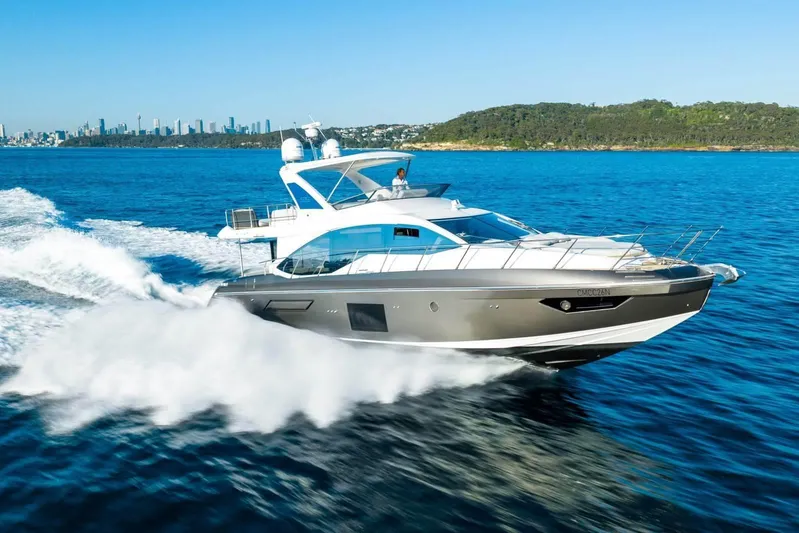  Yacht Photos Pics 2018 Azimut Flybridge yacht cruising on blue ocean near city skyline.