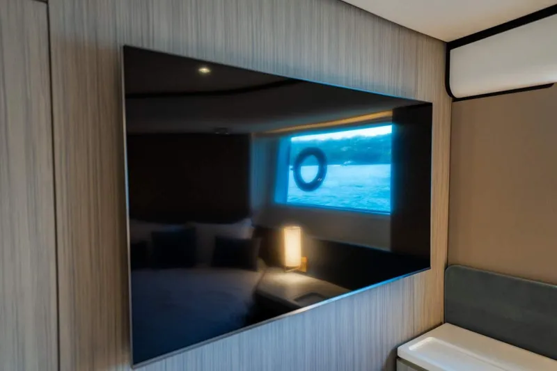  Yacht Photos Pics Luxurious interior of 2018 Azimut Flybridge yacht with wall-mounted TV and window view.