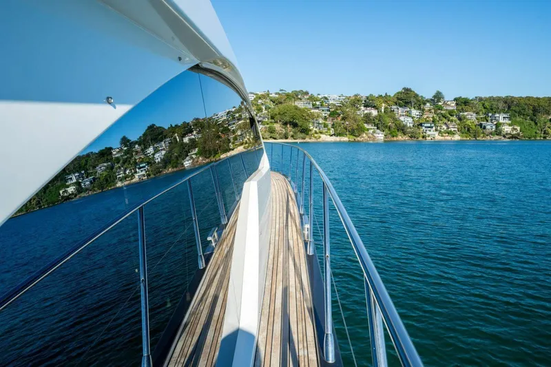  Yacht Photos Pics 2018 Azimut Flybridge yacht cruising on serene blue waters near a lush, green shoreline.