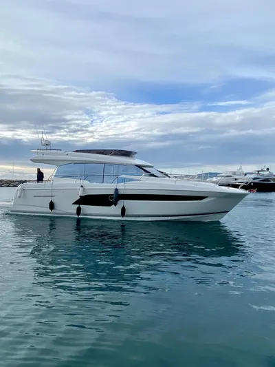  Yacht Photos Pics 2023 Prestige 520 yacht on calm water under a cloudy sky.